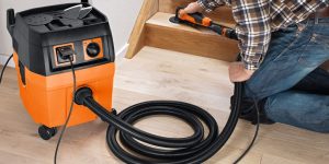 What is the best way to limit dust when using a power tool